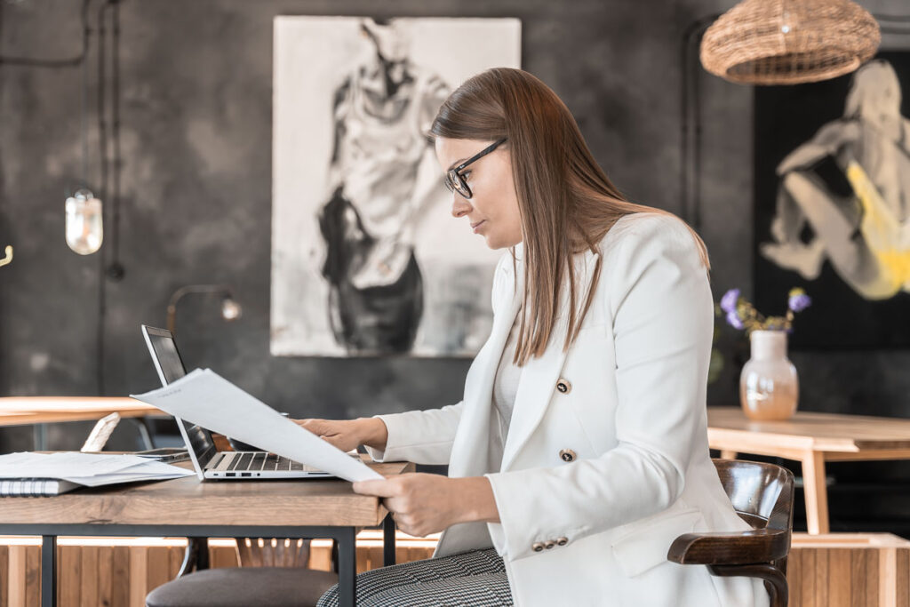 Kobieta w białej marynarce pracująca na laptopie w kawiarni - Fotografia Biznesowa Wrocław