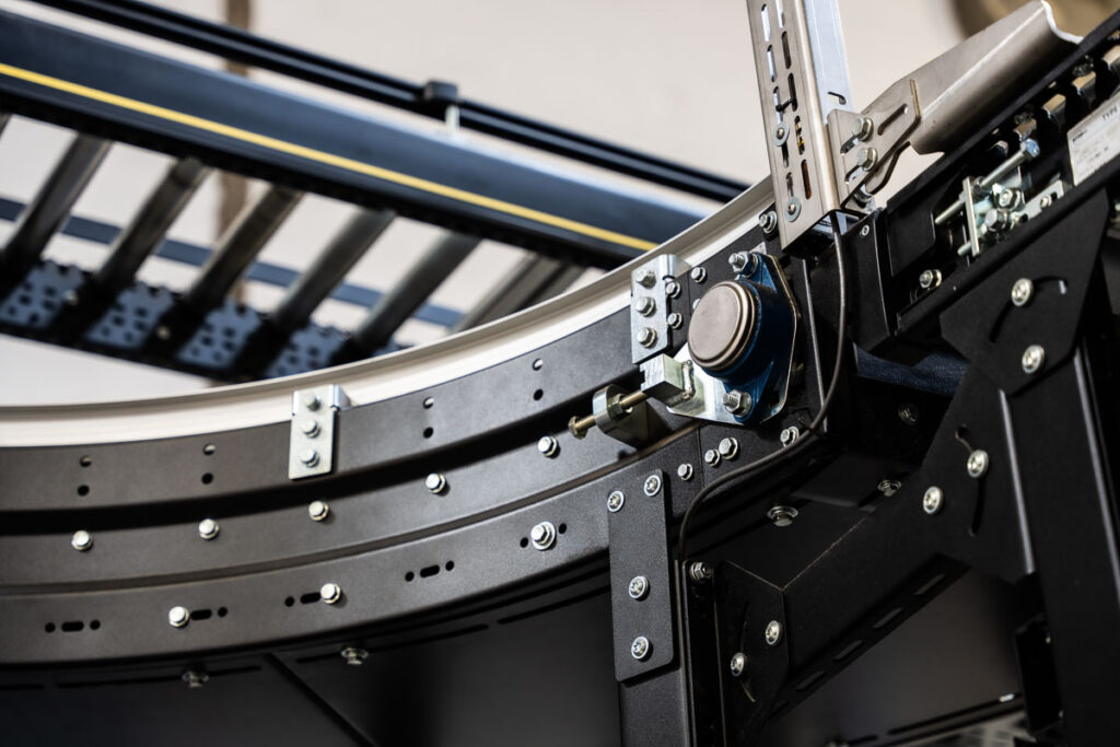 czarne zakrzywione przenośniki rolkowe w magazynie – fotografia przemysłowa Wrocław