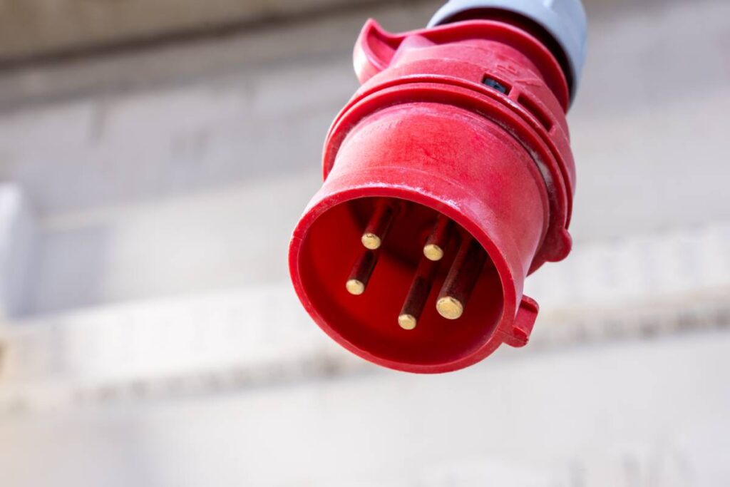 czerwona przemysłowa wtyczka zasilająca w zbliżeniu – fotografia przemysłowa Wrocław