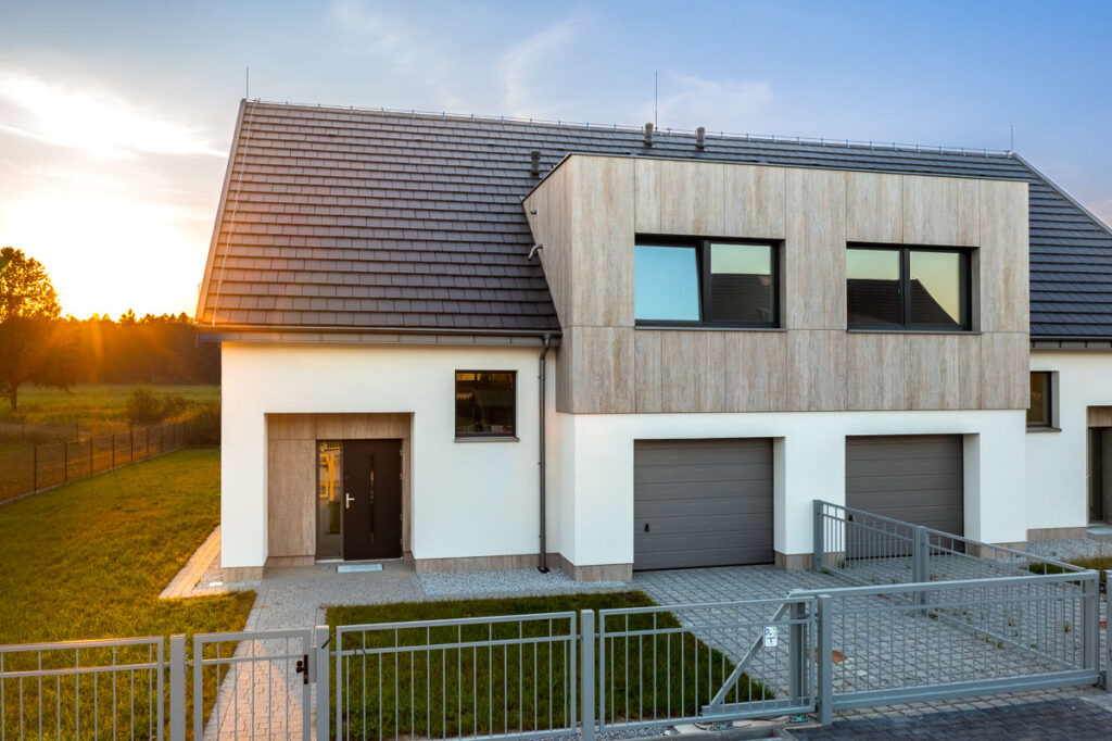 Bliźniaczy dom jednorodzinny z drewnianymi panelami elewacyjnymi o zachodzie słońca - Fotografia Inwestycji i Architektury Wrocław