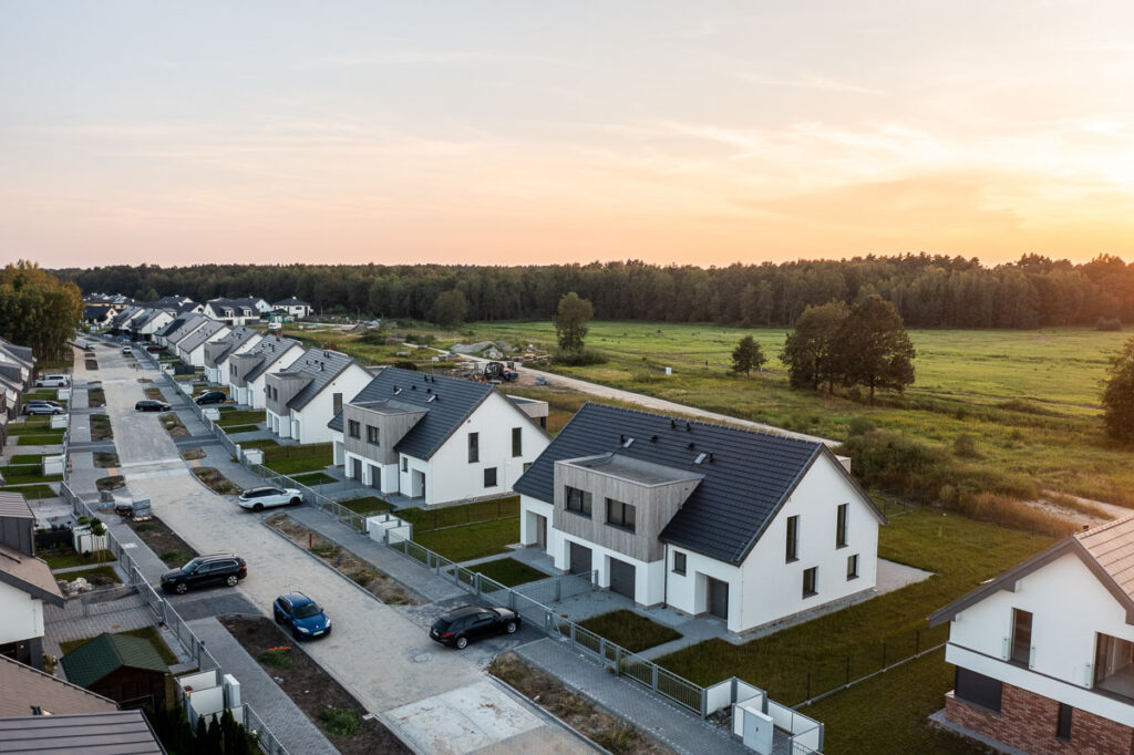 Osiedle nowoczesnych domów jednorodzinnych przy lesie o zachodzie słońca - Fotografia Inwestycji Wrocław