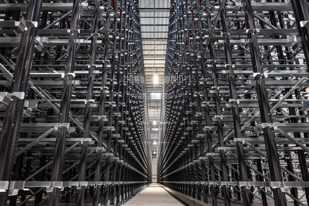 wysokie grafitowe regały pojemnikowe w nowoczesnym magazynie — fotografia przemysłowa Wrocław