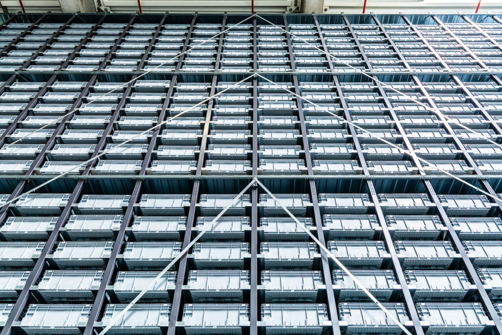 Wysokie regały pojemnikowe do automatycznej kompletacji w systemie logistycznym – fotografia przemysłowa Wrocław