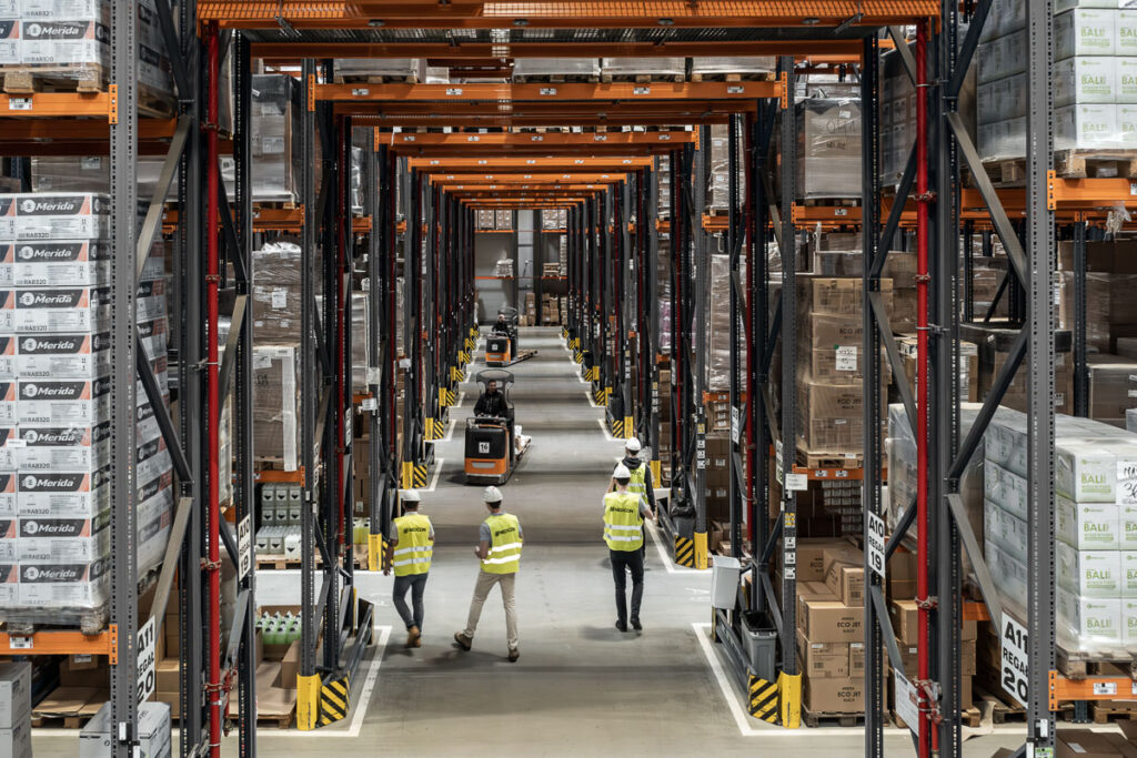 Pracownicy magazynowi między regałami wysokiego składowania – fotografia przemysłowa Wrocław