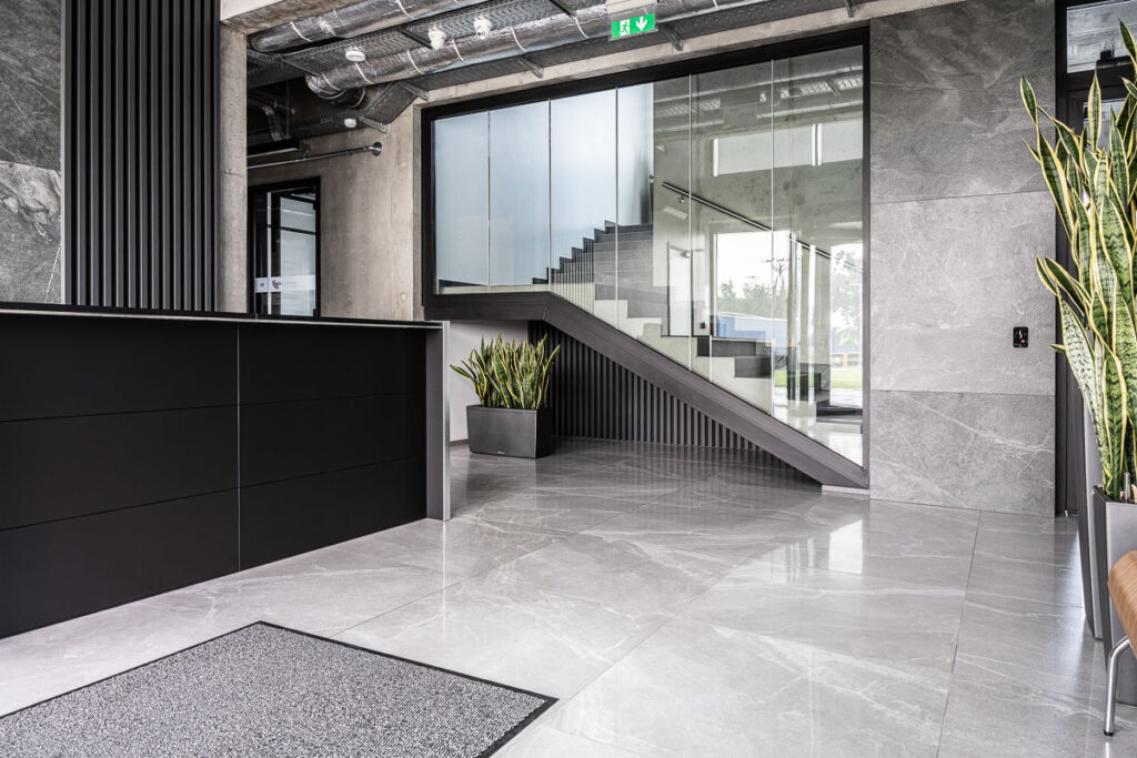 Nowoczesna recepcja z ciemną ladą i grafitową posadzką - Fotografia Wnętrz Wrocław