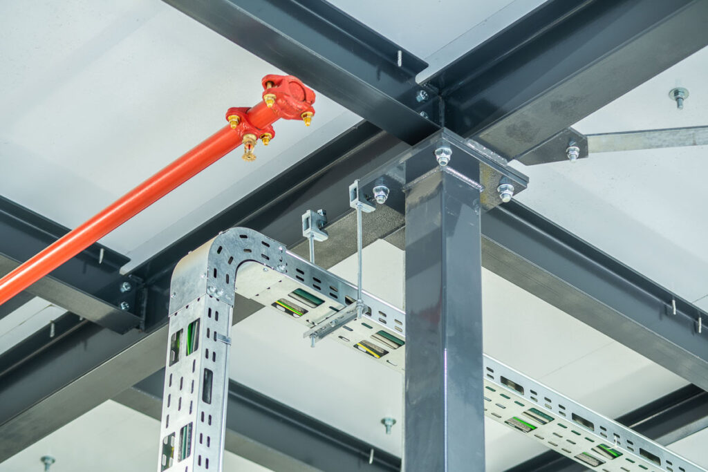 Zamocowanie instalacji tryskaczowej i trasy kablowej do stalowej konstrukcji słupa nośnego – fotografia przemysłowa Wrocław