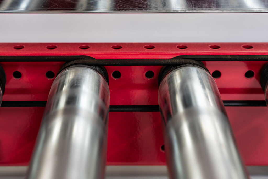 Zbliżenie na stalowe rolki przenośnika taśmowego w systemie transportu wewnętrznego – fotografia przemysłowa Wrocław