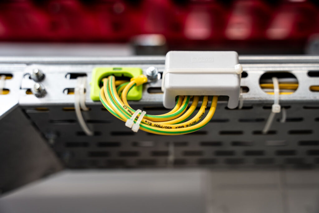 Zbliżenie na przewody uziemiające w trasie kablowej z żółto-zieloną izolacją – fotografia przemysłowa Wrocław