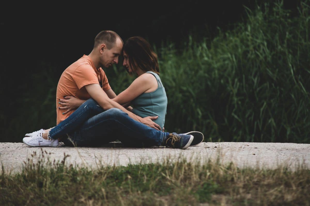 Para siedząca na betonie w miłosnym uścisku